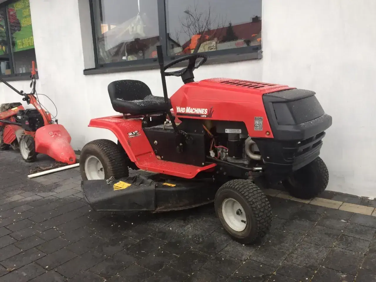 Czerwony traktorek kosiarka Yard Machines. Dowiedz się, jak zdjąć koło w kosiarce traktorku, by ułatwić konserwację.