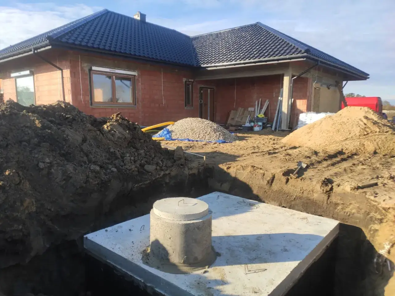 Budowa domu w toku. Widać rynnę, która będzie służyć do odprowadzenia wody z rynny do podziemnego zbiornika.